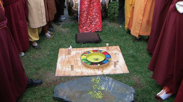 圖五）經少年女法王修法後抬開石板，彩色亂砂不見了，飛到了法台上缽中，而石板面上的砂已穿過石板，建成了種子字壇城，當下驚攝圍觀法王、尊者們和四眾行人