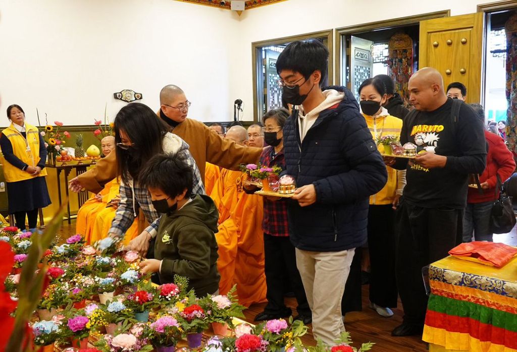 在聖蹟寺出家眾的協助指引下, 參加法會的信眾依序上供